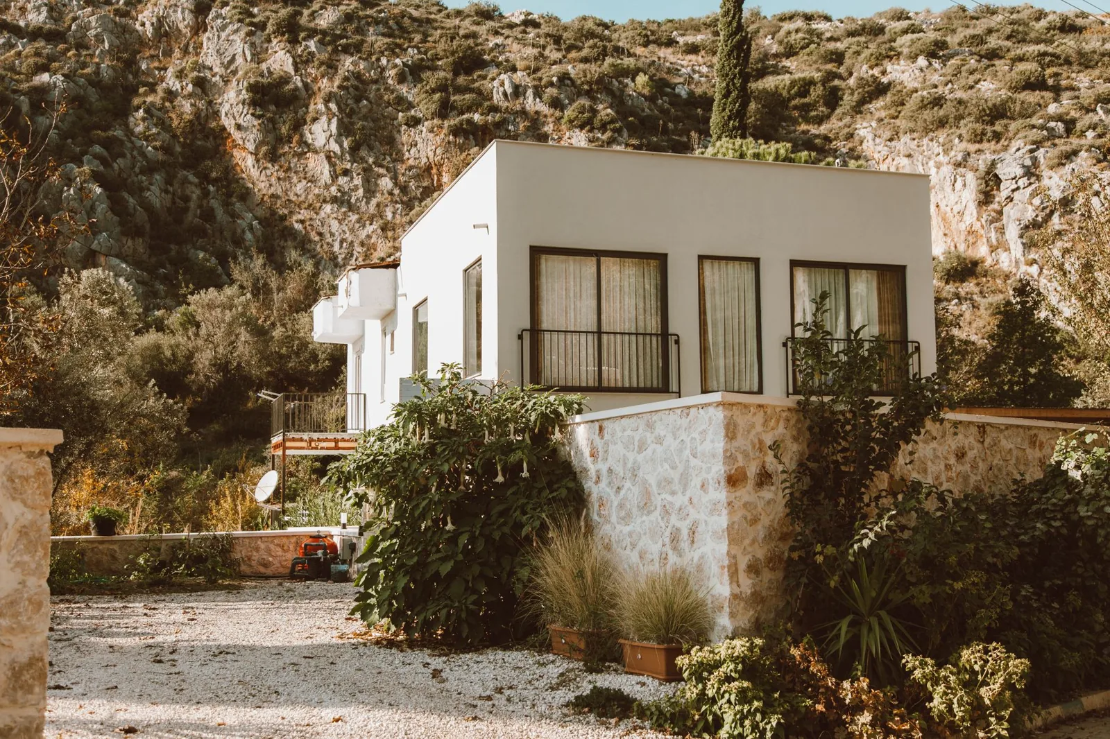white house exterior color schemes — a white villa with dark-framed windows and stone accents