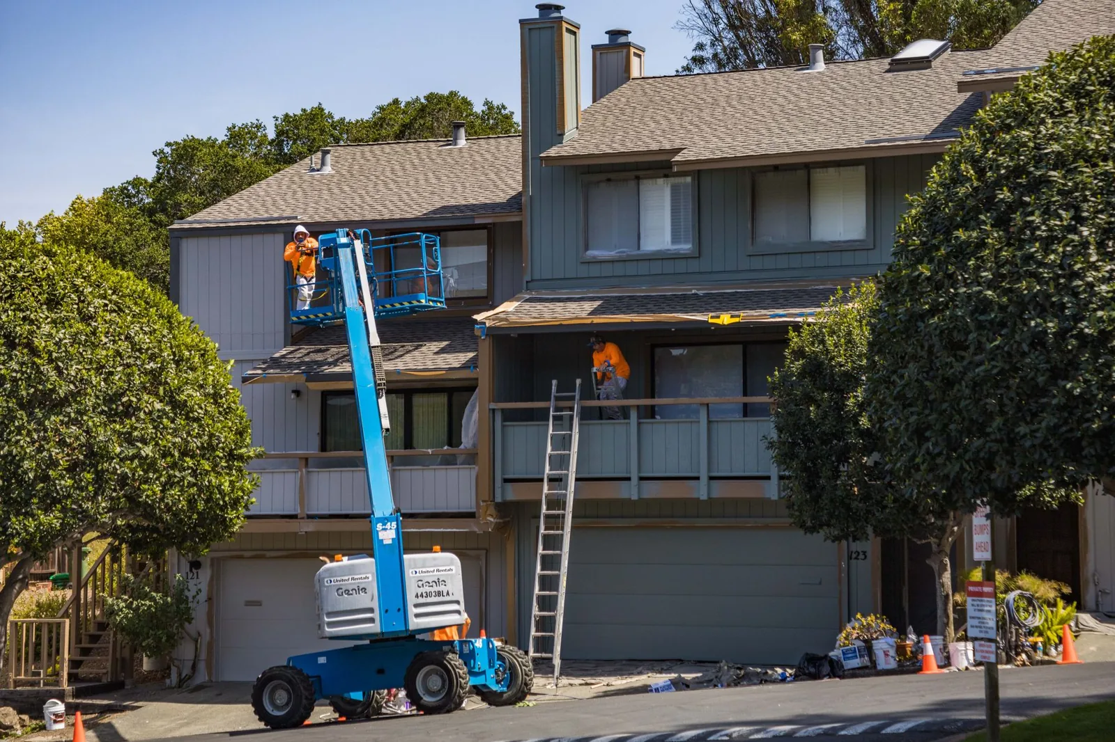 Workers painting a house exterior during renovation