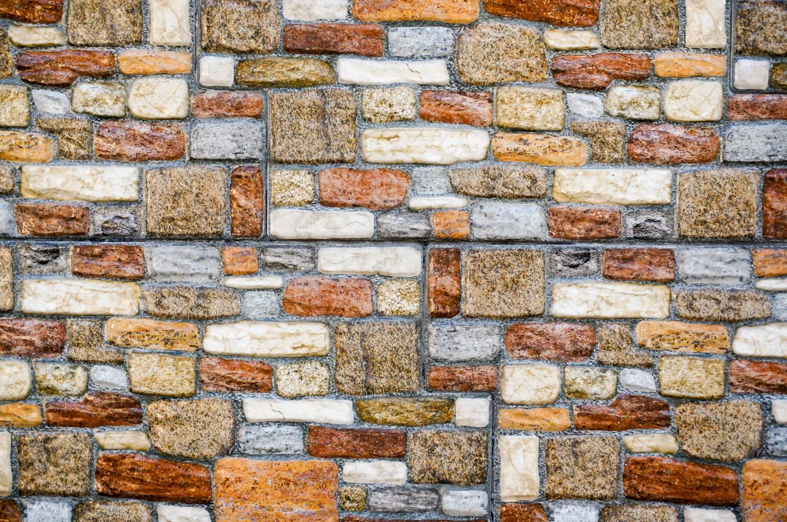 A close-up of a textured brick wall with diverse colors and patterns.