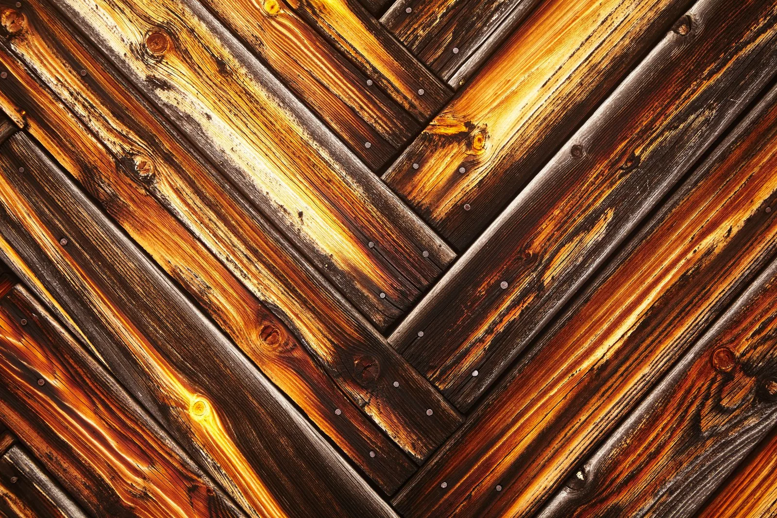 Weathered wood boards showing how stain preserves the natural grain compared to painted siding