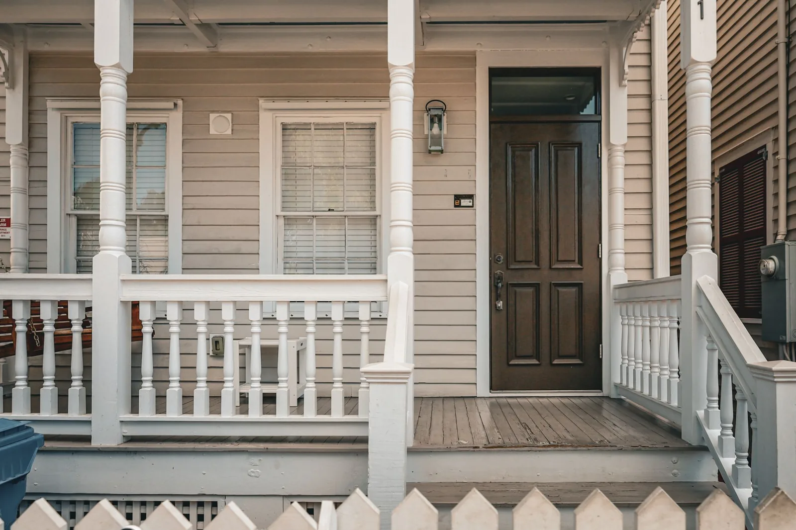 front porch design ideas with a classic wooden entry and white picket fence